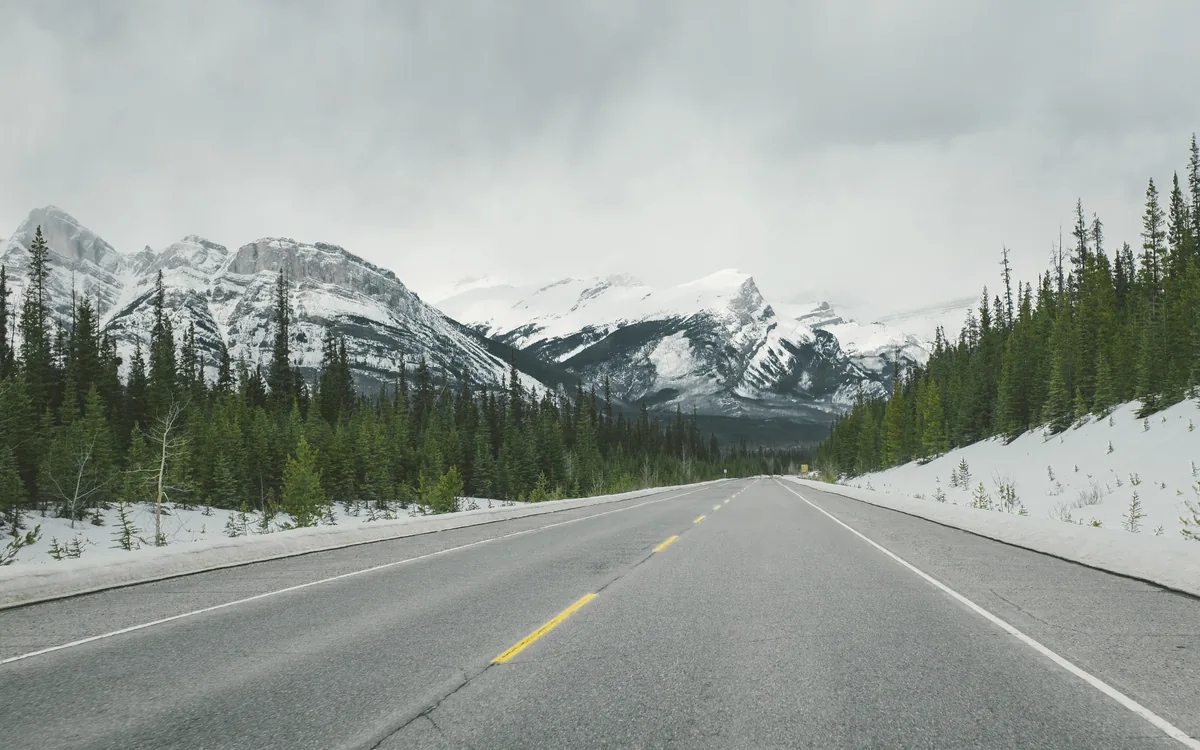 Open road leading toward mountain peaks—the path to a clearer destination
