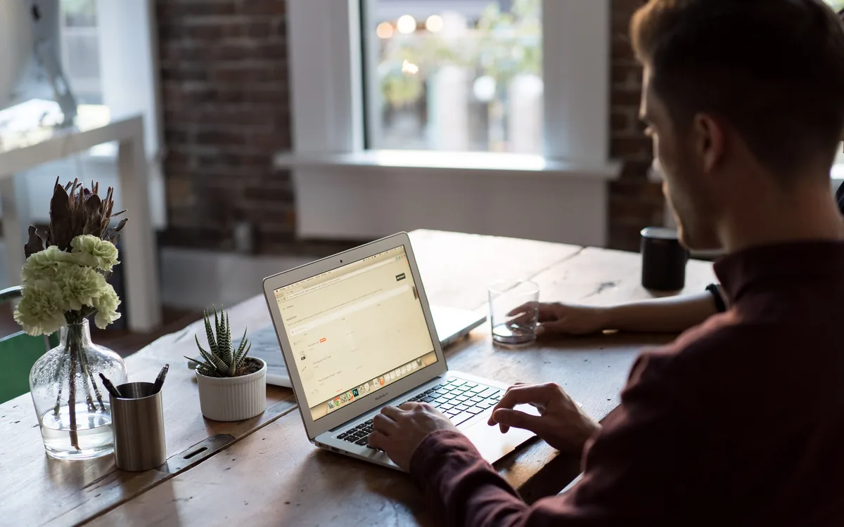 Person at a desk working on a laptop in a small office